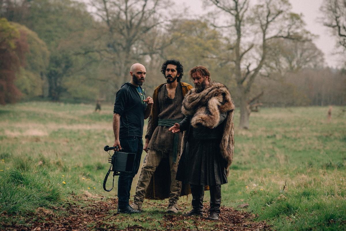 Director David Lowery, Dev Patel and Joel Edgerton on the set of “The Green Knight.” Cr: Eric Zachanowich/A24